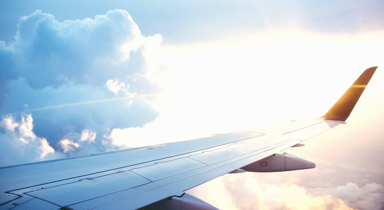 Airplane wing over clouds